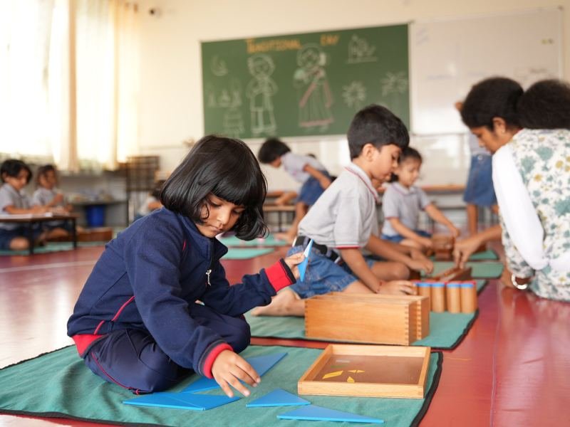 Children working with Montessori materials guided by their teacher